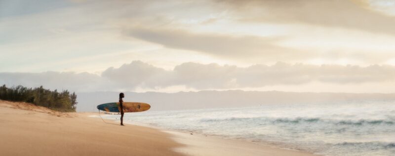 surfer checking out the waves on a beach on Oʻahu