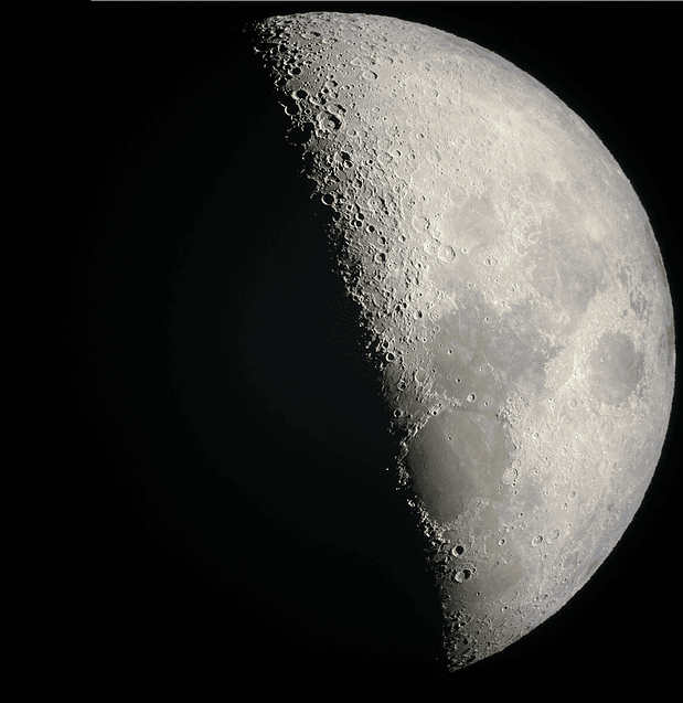 Half moon with its craters in sharp detail, seen through a telescope at the Ko Olina star show